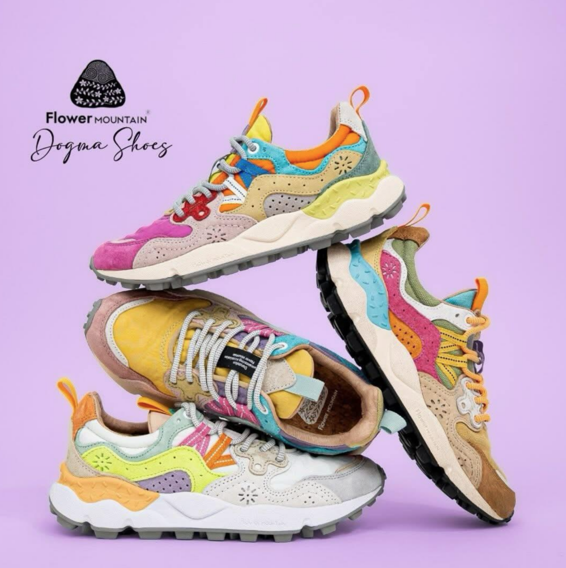 Quatro sapatilhas Flower Mountain coloridas empilhadas. Design outdoor vibrante com texturas e padrões sobre fundo lilás.
